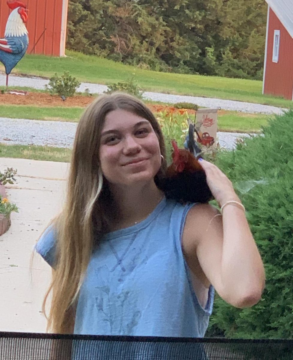 Sophomore Avery Schmidt poses with her rooster Samuel, who she trained to fly up onto her shoulder. Schmidt has even had Samuel fly up onto her head before. 