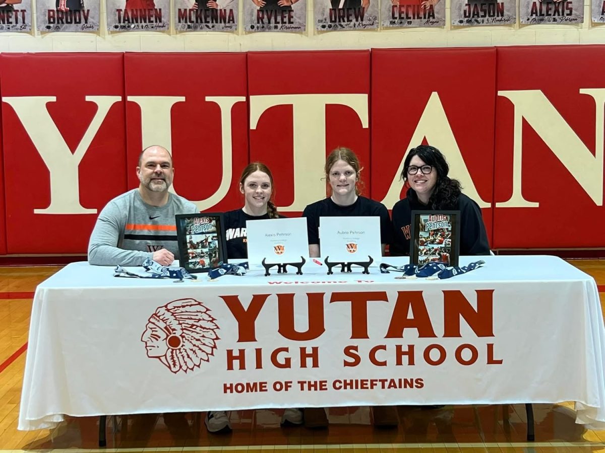 Seniors Alexis and Aubrie Pehrson pose with their parents after signing to Wartburg college for women's wrestling. Beside wrestling, Alexis plans to study forensic science while Aubrie plans to study biology. 