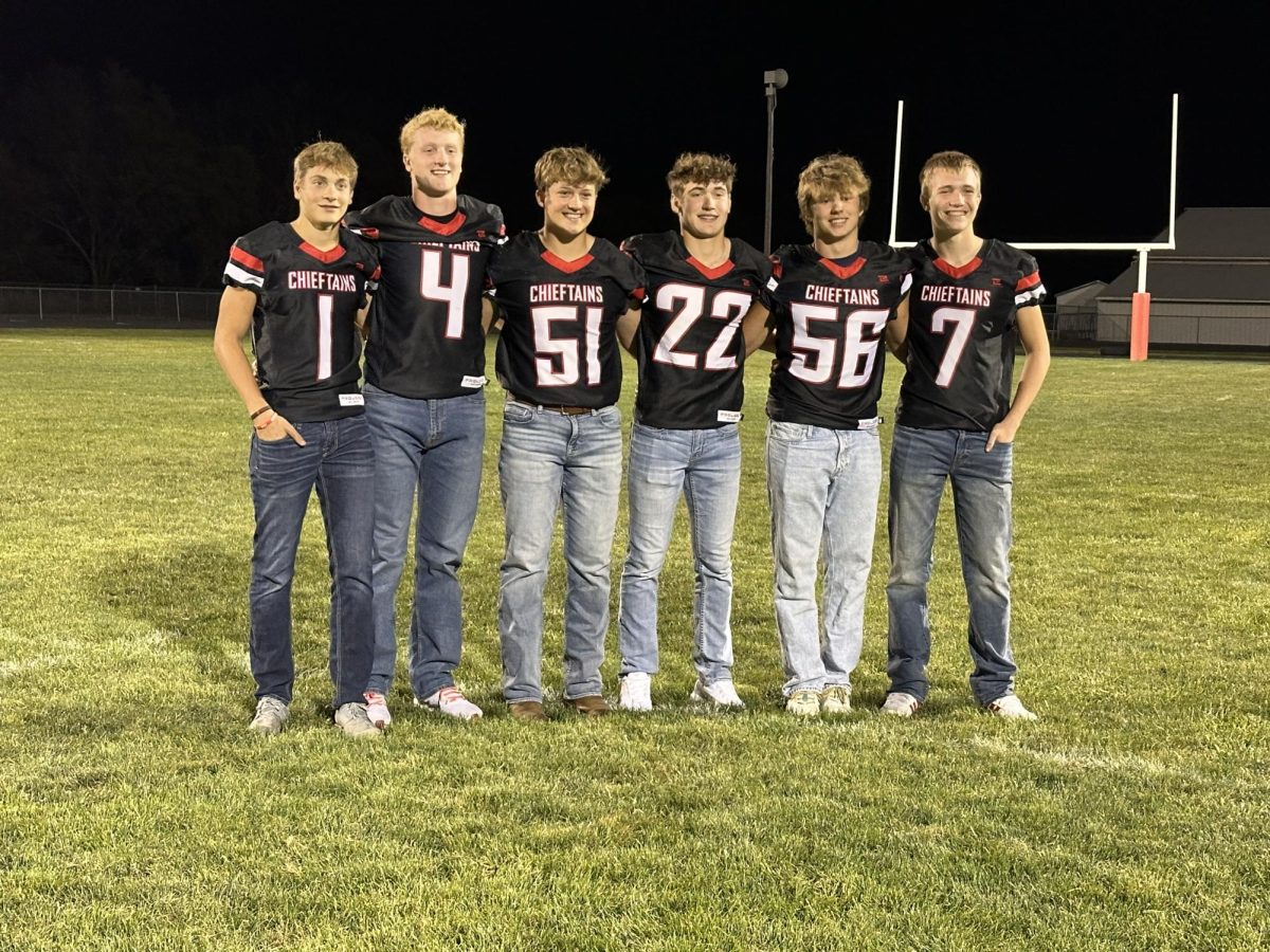 The group of boys pose for a picture with their respective jerseys on. Football is the one sport all six boys participated in together all four years of high school.
