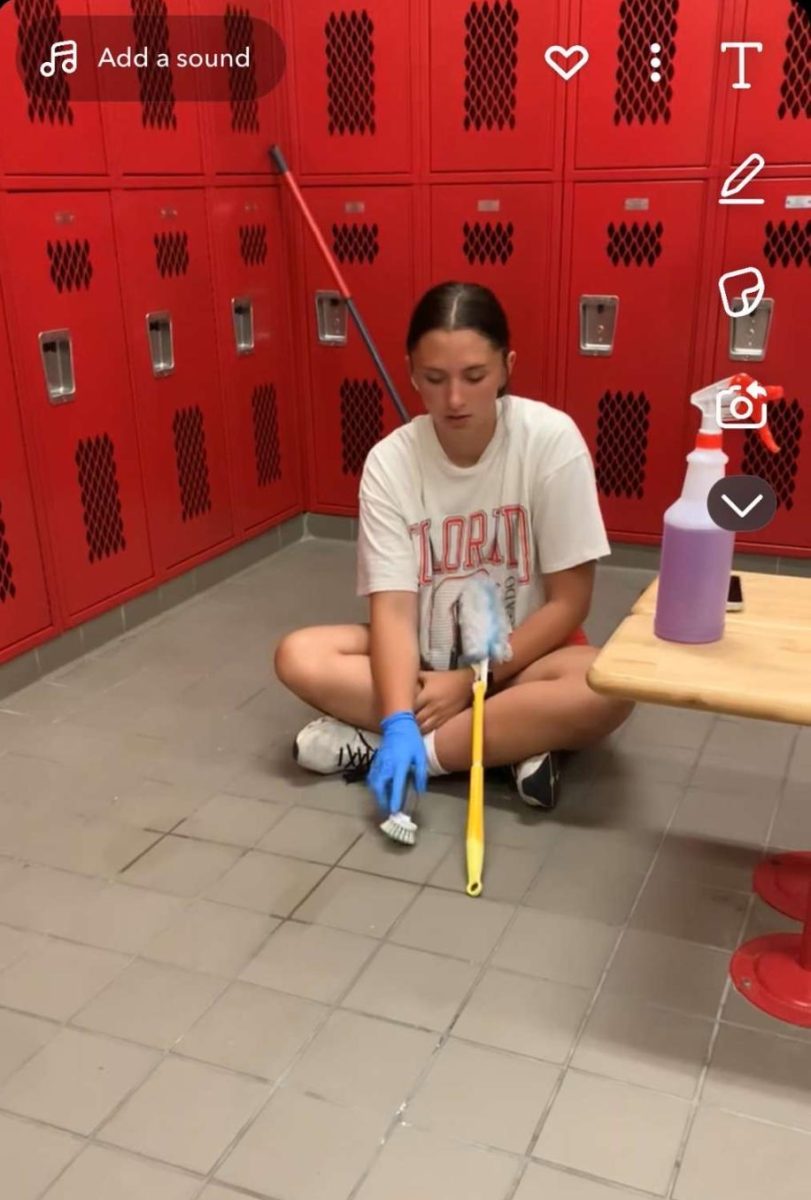Junior Jancye Long scrubs the locker room floor at the high school. Long's favorite area to clean was the elementary classrooms.