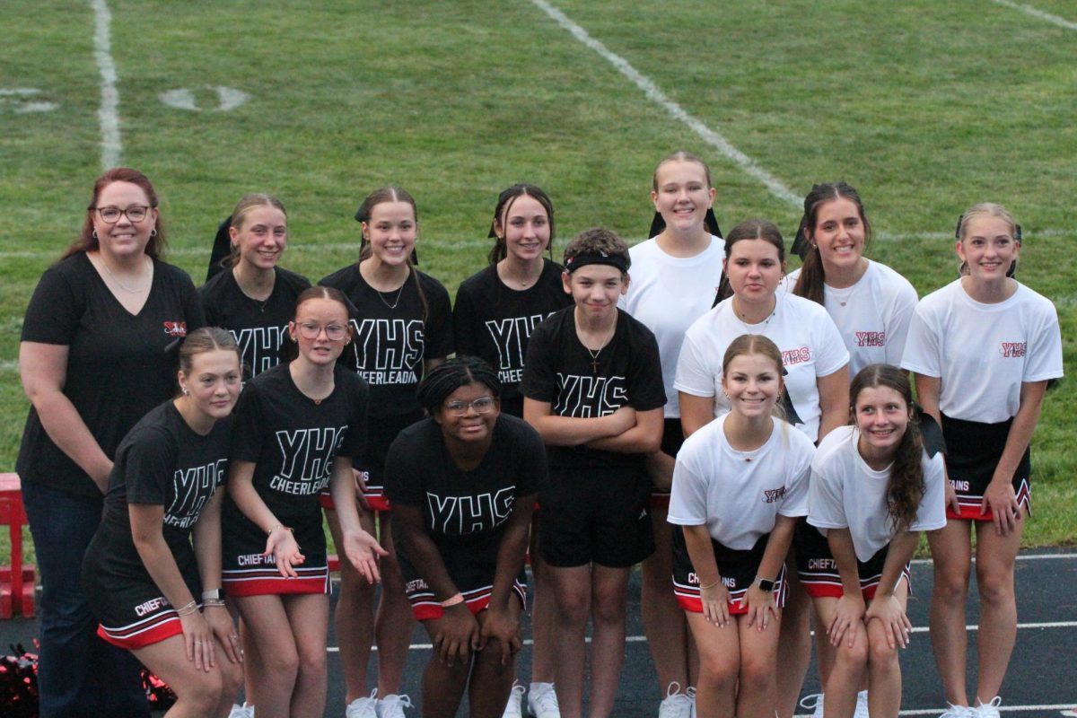The Yutan cheer team poses for a picture with their new cheer coach after the football scrimmage. There are eight veteran and five new cheerleaders on the team this year.