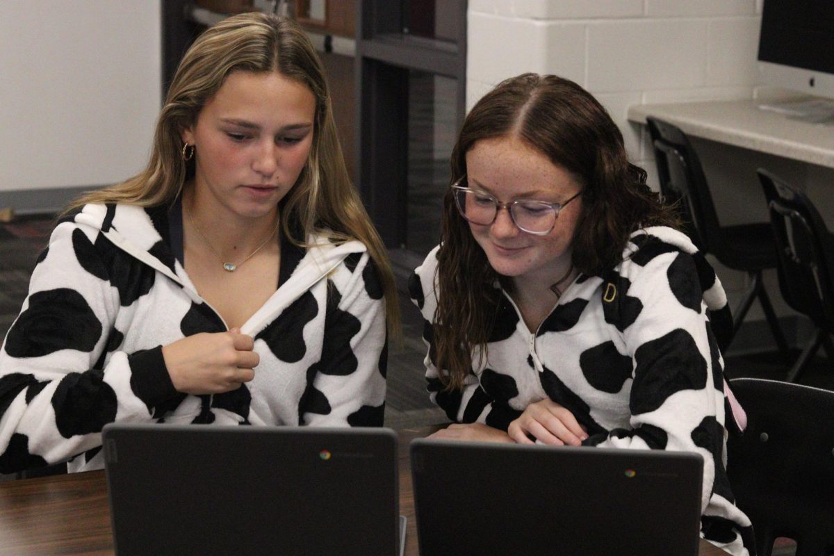 Juniors Leah Thompson and Lexi Engel work together on a SENCAP assignment during homecoming week. Thursday was Dynamic Duo Day, where two people dress up together in matching costumes. “It was really fun to dress up with Leah because we were THE dynamic duo,” Engel said.