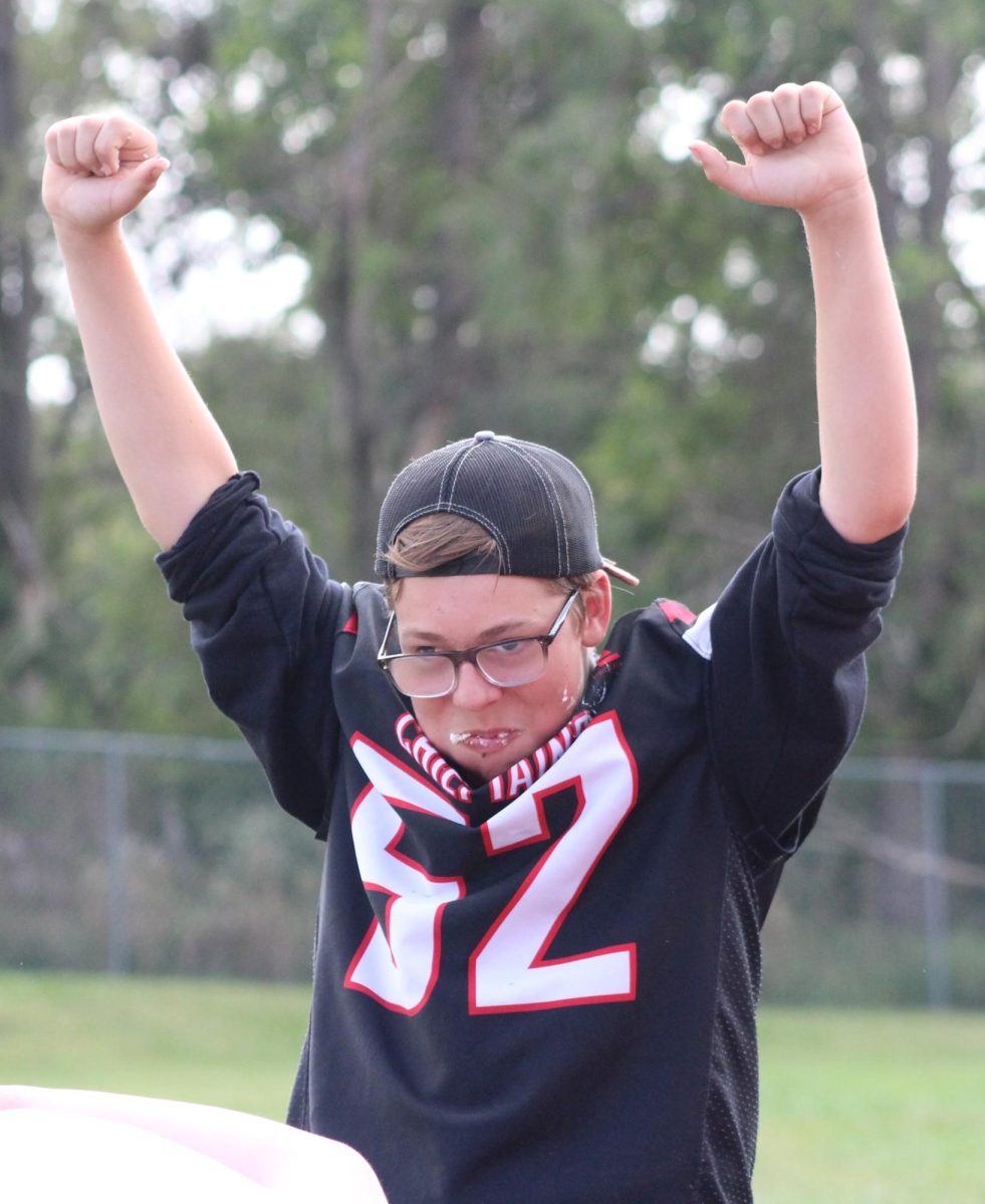 Sophomore TJ Ledden puts his hands up in celebration of winning the sophomore through senior cupcake-eating contest. This was Ledden’s first year participating in the cupcake-eating contest. “Homecoming week was really fun, especially winning the cupcake-eating contest, even though I cheated…I used my fingers and everyone saw, but Mrs. Heise didn’t. So I did not get in trouble and still won,” Ledden said.