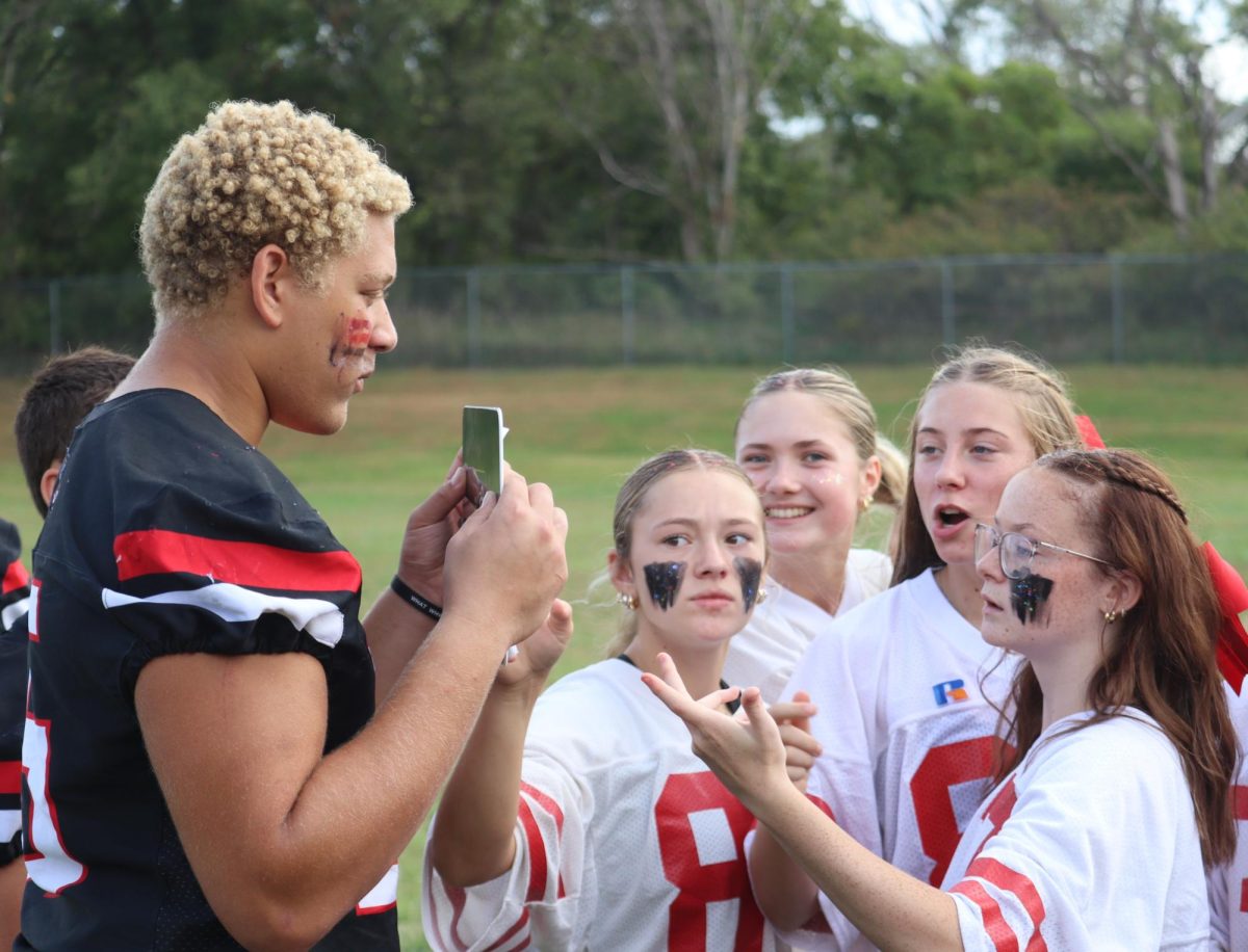 From left to right, juniors Peyton Reed, Kylie Woster, Aubrey Zeleny, Emmy Tederman and Lexi Engel look at the next play call during powderpuff football. This was the second year that the juniors competed against the seniors in powderpuff. “I coached because I wanted to represent my class and I love football, so it was a lot of fun,” Reed said.
