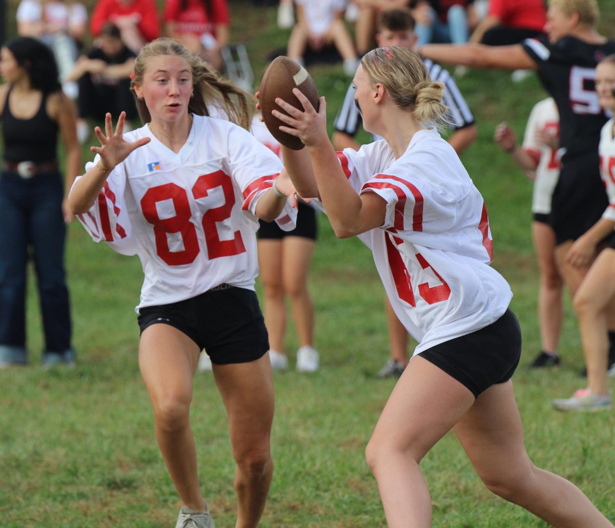 During the second annual powderpuff football game, junior Charlie Weeder gets ready to hand off the ball to junior Emmy Tederman. The seniors won the game 21-7. “Even though we lost, it was a fun chance to play a sport I normally don’t play,” Tederman said.