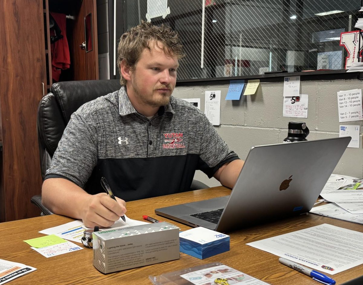 Activities director Alex Nielsen checks his emails before the school day starts. In addition to activities, Nielsen is also in charge of transportation.