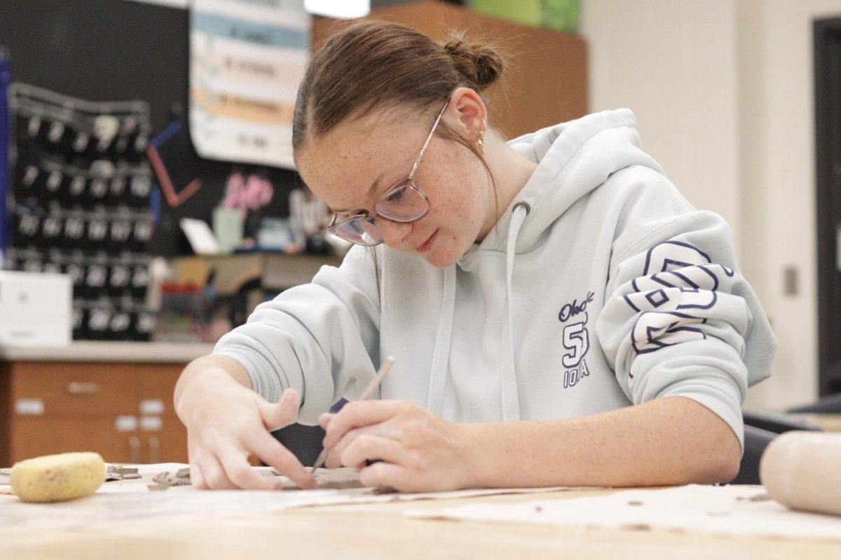 Junior Lexi Engel uses a tool to form a piece of clay. Since Yutan is so small, instead of offering painting or sculpture classes, students can experiment with different mediums in class. 